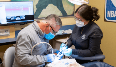 dentist and dental hygenist working patient