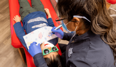 dental hygenist working on child patient